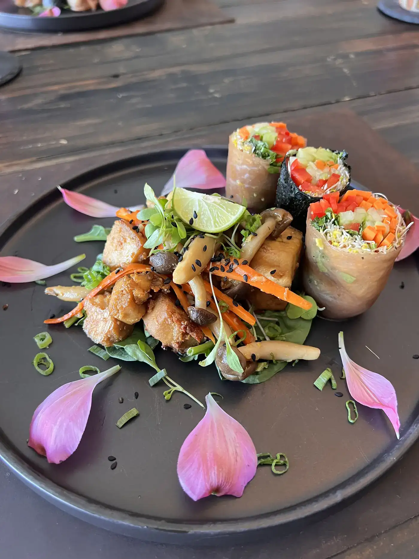 A plant-forward meal plated with fresh herbs and flower petals